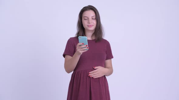 Happy Young Beautiful Pregnant Woman Thinking While Using Phone