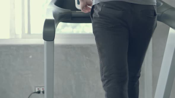 Closeup young man exercise with running on treadmill in the gym.