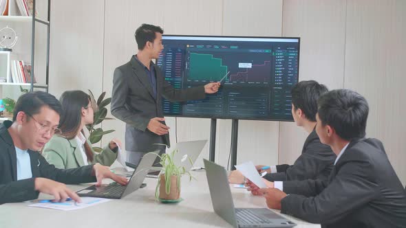 Asian Businessman Presentation To Business Colleagues About Financial Chart Trading Online On Tv