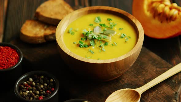 Fresh Pumpkin Soup in Bowl on Chopping Board