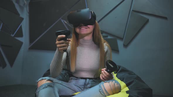 A Teenage Girl Sits in a Club with Virtual Glasses and Plays
