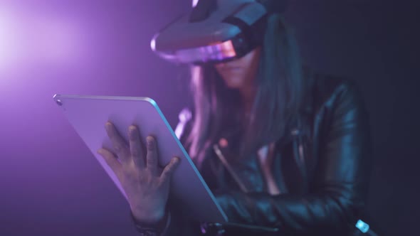 Unrecognizable woman in VR glasses browsing tablet