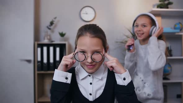 Teen Girl which Closed Ears with Hands to Escape from Loud Sound from Her Dancing Singing Sister