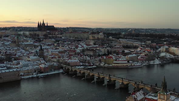 Prague Castle and Charles Bridge. Aerial View. Cityscape Skyline at Winter, Snow Capped Buildings an