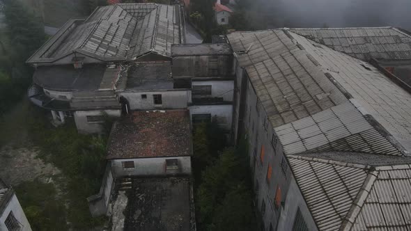 Drone flying over roof of Caramulo big Sanatorium old abandoned building on misty day, Portugal