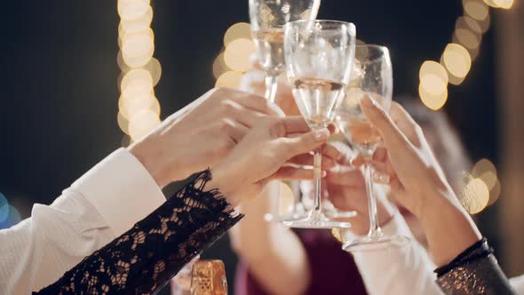 Millennials at Party or Holiday Sitting at Table Drinking Champagne Eating Chatting or Communicating