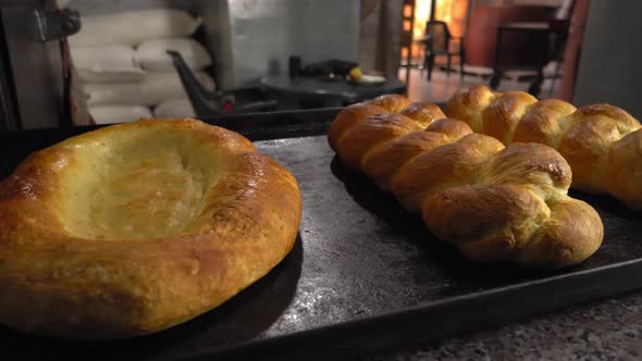 baked pastries in form of rolls and bread lie on table against background bakery