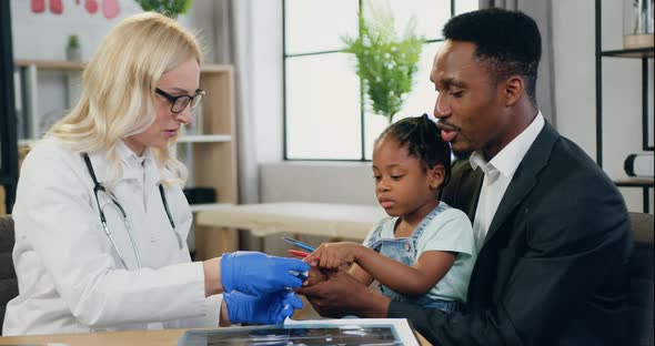 Pediatrician Applying Pulse Oximeter to Cute African American 6-Aged Girl to Check Blood Oxigen