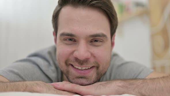 Close Up of Beard Young Man Smiling at Camera in Bed