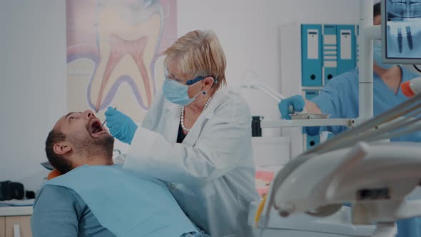 Oral Care Medic Using Dental Tools to Do Teeth Examination