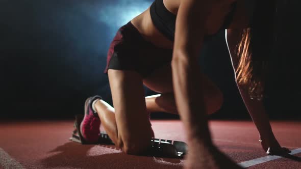 Professional Woman Athlete on a Dark Background Gotovtes To Run the Sprint of Jogging Shoes