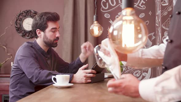 Man Having a Video Conference on His Tablet While in a Coffee Shop