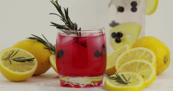 Adding Lemon Slice, Rosemary in a Glass with Soda Lemonade Red Cocktail