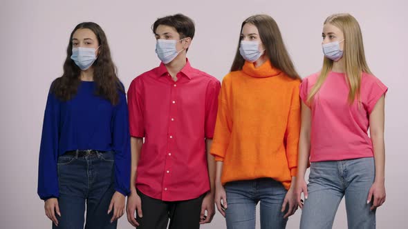 A Group of Young People Wearing Medical Masks Look Away and Then Straight Into the Camera