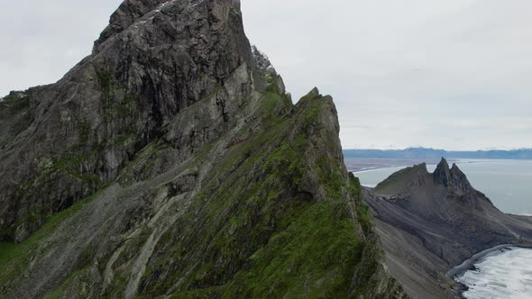 Drone Towards Peak Of Vestrahorn Mountain Under Cloudy Sky