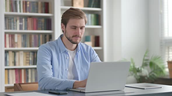 Man Shaking Head As Yes Sign While Using Laptop