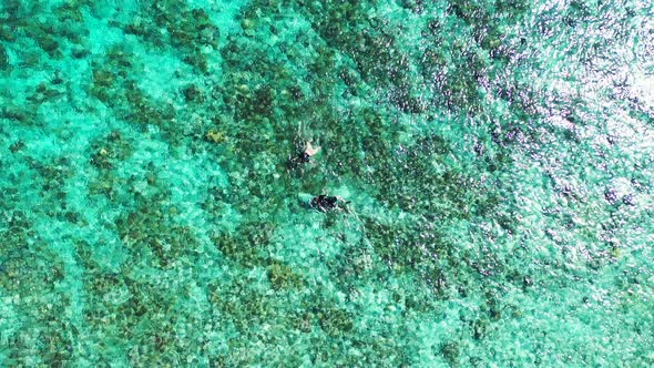 Tropical fly over tourism shot of a white sandy paradise beach and aqua turquoise water background i