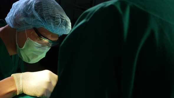 Low Angle Shot of Professional surgeons team performing surgery in operating room, surgeon, Assistan alt