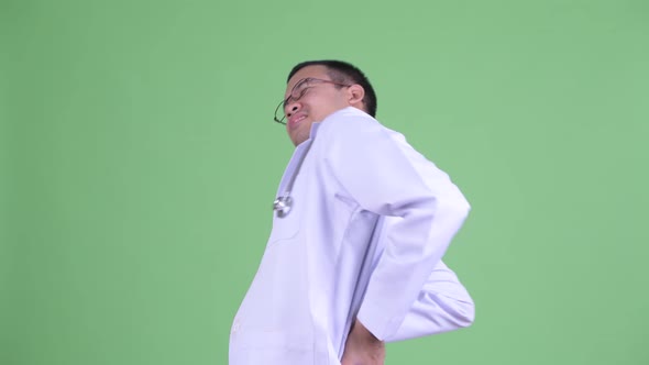 Stressed Asian Man Doctor with Eyeglasses Having Back Pain