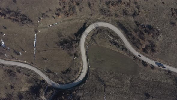 Descending on curvy road while car is passing 4K drone video