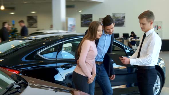 Couple Looks at the Contract at the Dealership 1080p