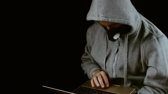 White male in his 30s working from home on a computer with facial mask during corona virus outbreak