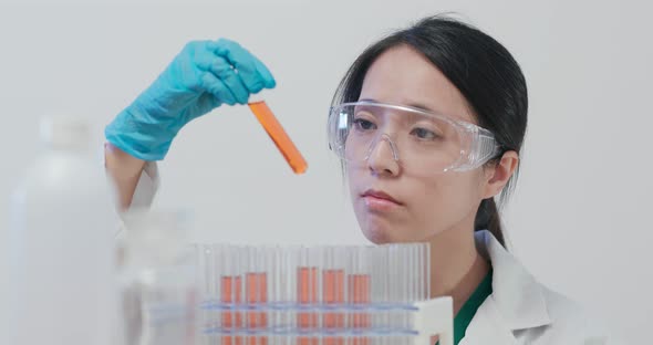 Scientist making observation of the test tube