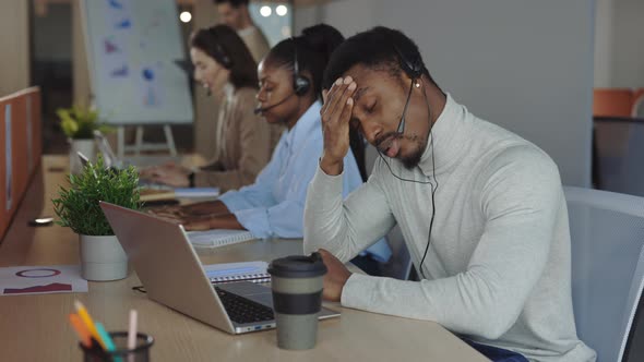 Male Operator with Headset Suffering From Headache in Office