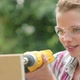 Woman wearing safety goggles drilling plywood with electric drill - VideoHive Item for Sale