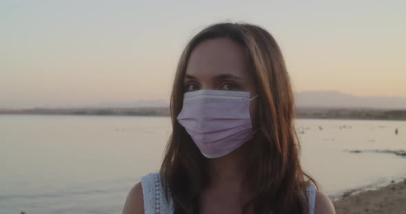 Portrait of Woman in Medical Face Mask in Public Beach
