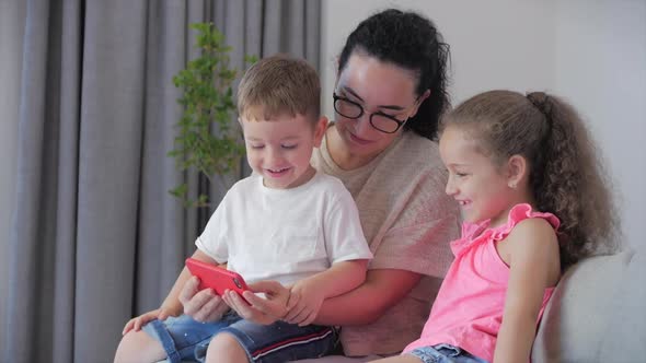 Happy Family,mom and Cute Little Kids,mother Playing with Children at Home Relaxing Use a Smartphone