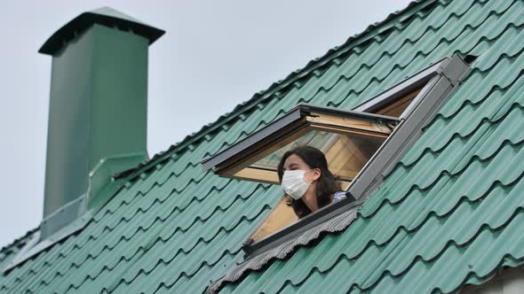 Quarantine is Over Concept. Young Woman Open Roof Window Taking Off Medical Protective Mask