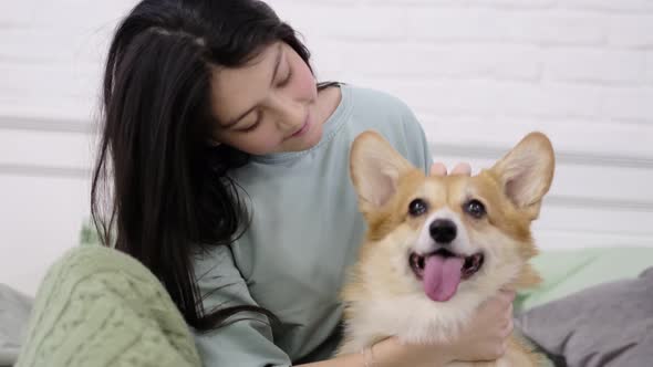 Young Teen Girl Hugging Corgi Dog with Love