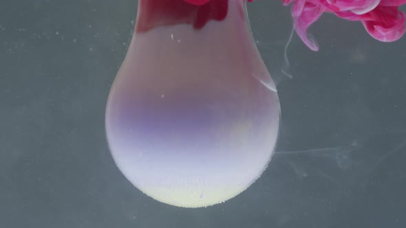 Incandescent light bulb veiled by red paint alt