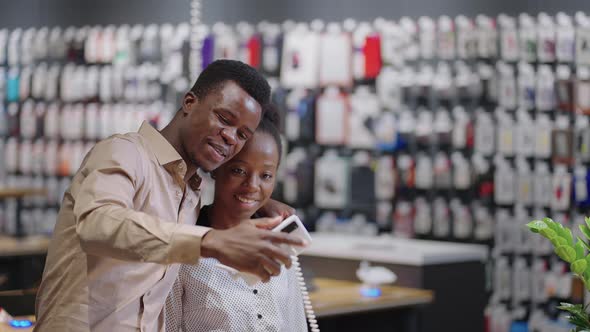 Happy Afroamerican Couple in Digital Equipment Store Shoppers are Checking Camera of Exhibition