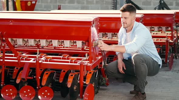 Younf Farmer Choosing Spare Part for Agriculture Machinery