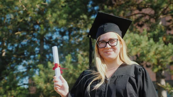 Portrait of a Happy Female Graduate in Mantle and Cap