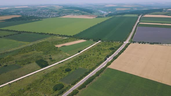 Aerial View  Video of the Road That Crosses the Fields with Different Crops