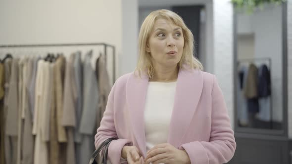 Portrait of Excited Female Shopaholic Standing in Luxurious Clothing Store During Black Friday Sales