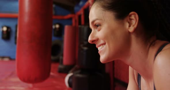 Smiling female boxer standing in fitness studio