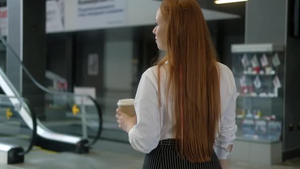 manager of company in formal clothes goes up escalator to the corporate office