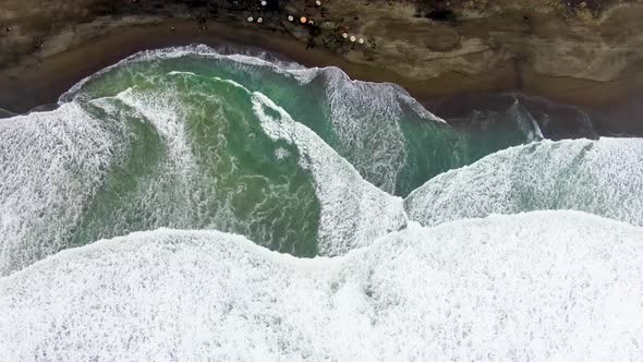 Waves breaking on Suwuk beach in Kebumen, Indonesia. Aerial top-down sideways