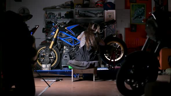 The camera zooms in on a young woman from behind. Woman enthusiastically repairs