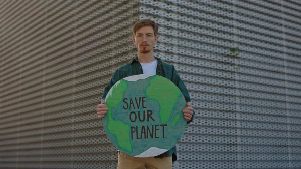 Man Holding Banner with Save Our Planet Phrase on Street