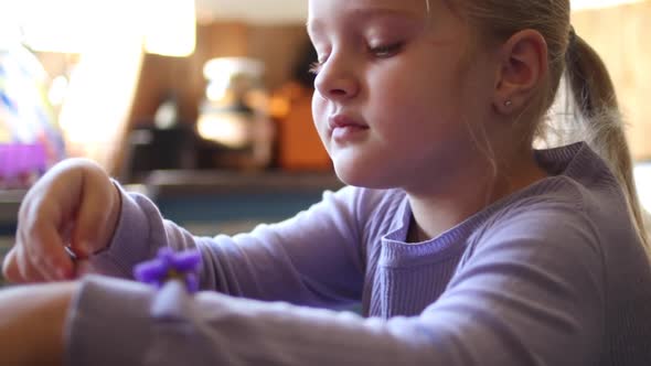 Close up footage of a young five year old girl playing with clay in the kitchen of the house she liv