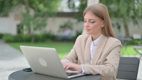 Young Businesswoman with Laptop Shaking Head As Yes Sign in Outdoor Cafe