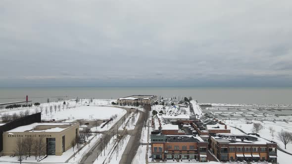 Aerial view facing Lake Michigan with a cloudy sky in the horizon. Snow on the in winter.