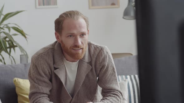 Cheerful Man Watching Movie at Home