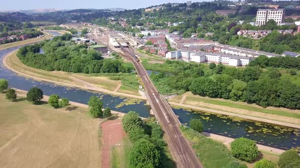 Aerial fly over of a moving train and the River Exe in Exeter, England