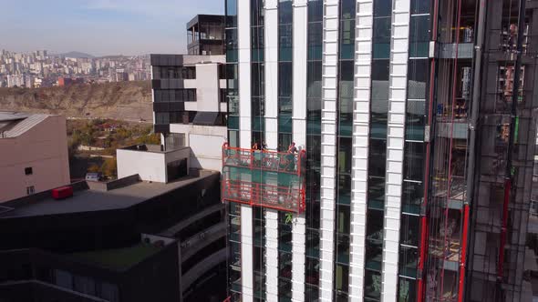 Suspended Cradle And Workers On The Building Construction